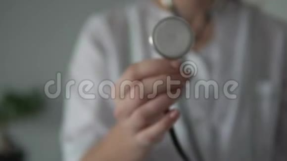 一只雌手拿着一个听诊器靠近摄像机视频的预览图