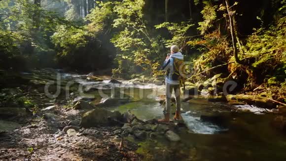清晨一位女摄影师在一片风景如画的森林一幅美丽的风景视频的预览图