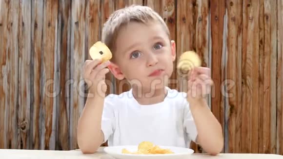 一个小男孩高兴地吃薯片不健康饮食的孩子不健康的食物视频的预览图