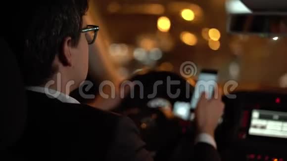 在夜城开车的商人在电话里滚动视频的预览图