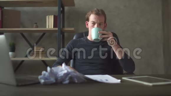 愤怒和沮丧的年轻人坐在一堆皱巴巴的文件面前沮丧的商人视频的预览图