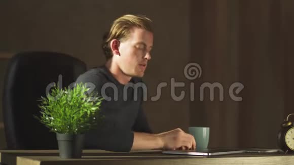 英俊的商人在现代办公室的笔记本上工作喝咖啡一位成功的青年企业家视频的预览图