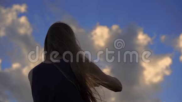 日落时分一名带风筝的年轻女子在热带海滩上慢镜头拍摄视频的预览图