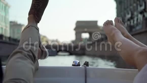 年轻夫妇在城市里开船或游艇双腿赤脚婚礼当天新娘新郎骑马视频的预览图