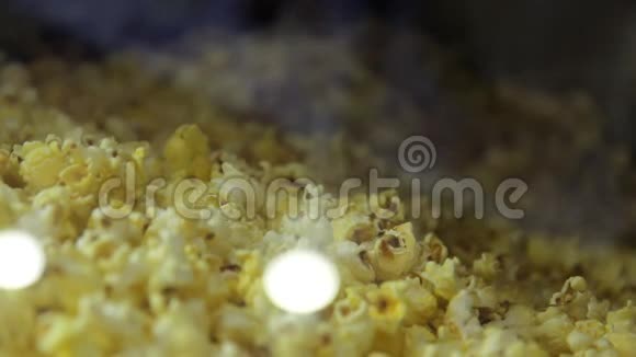在cimena电影院的电影院里一个人用奶酪焦糖爆米花炸玉米装大塑料桶视频的预览图