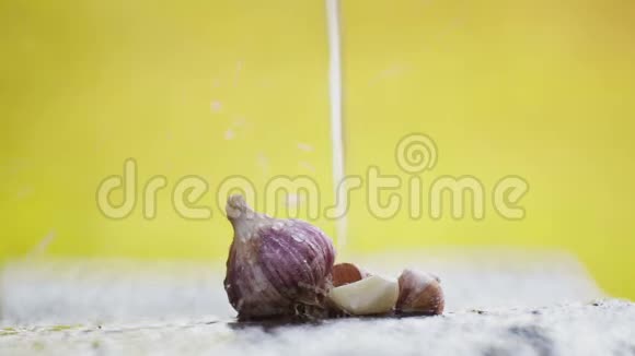 新鲜的大蒜头放在一张桌子上放在一股水流下视频的预览图