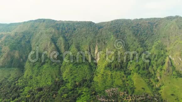 空中来自印度尼西亚苏门答腊岛上方的托巴湖和萨莫西尔岛巨大的火山岩覆盖着水巴塔克村绿色的视频的预览图