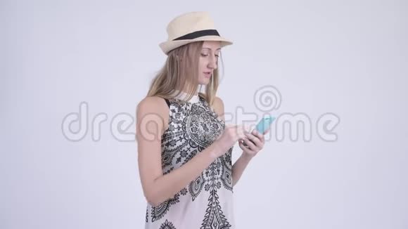 戴着帽子的金发女游客用电话接坏消息视频的预览图