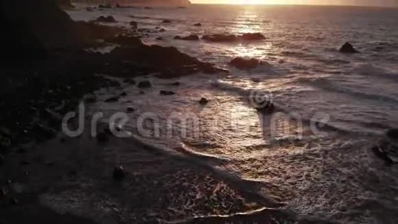 特内里费北岸美丽的日落一个有大石头和黑沙的海滩从上面看视频的预览图