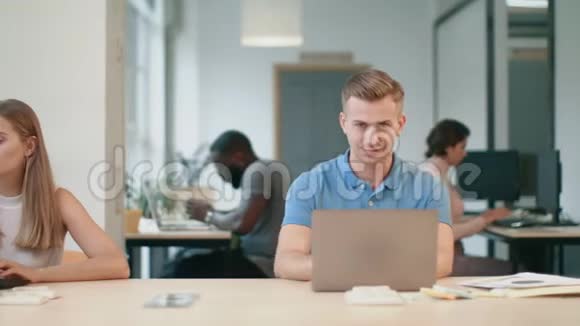 在同事办公室工作在笔记本电脑上的年轻人做男人的快乐男人视频的预览图