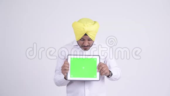 快乐的印度锡克族商人在展示数码平板电脑时感到惊讶视频的预览图