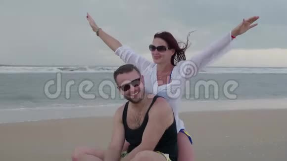 一对漂亮的夫妻和一个女朋友快乐地在海边休息视频的预览图