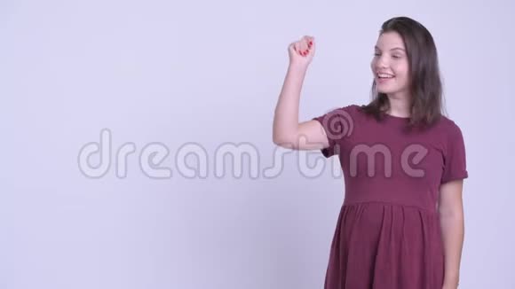 快乐的年轻美丽的孕妇拍打手指展示一些东西视频的预览图