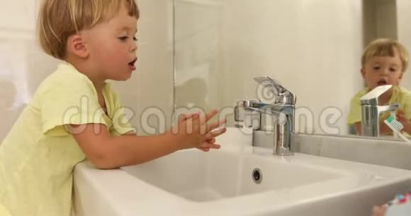 可爱的男孩在镜子旁洗手视频的预览图