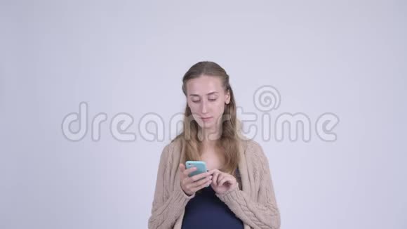 快乐的年轻孕妇用电话看起来很惊讶视频的预览图