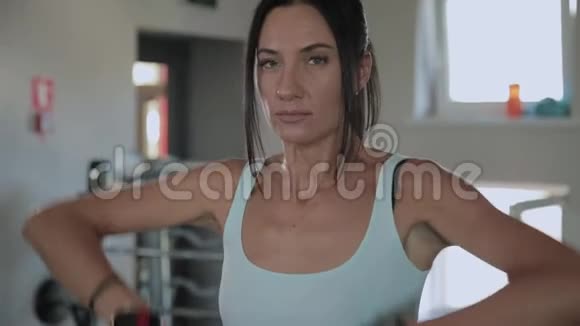 漂亮的运动女人在健身房里举起下巴视频的预览图
