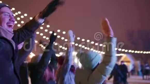年轻人在城市广场的圣诞音乐会上聚会朋友们用举手和跳舞的方式跳得很开心视频的预览图
