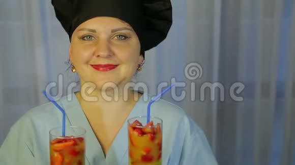 一个微笑的厨师手里拿着新鲜水果鸡尾酒的眼镜视频的预览图