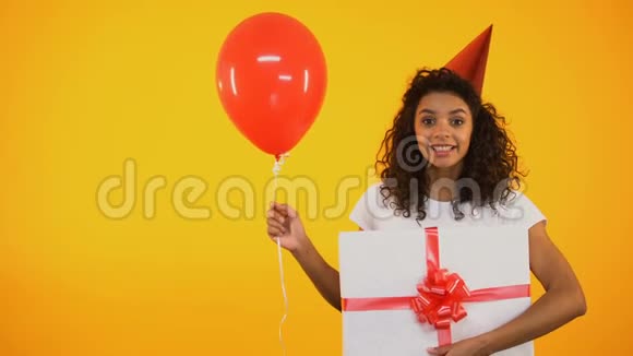 快乐的少年拿着气球和巨大的礼品盒庆祝生日问候视频的预览图