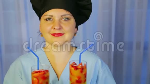 一位微笑的厨师手中拿着新鲜水果鸡尾酒的酒杯视频的预览图