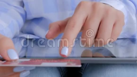 网上购物女性使用平板电脑和信用卡近距离观看视频的预览图