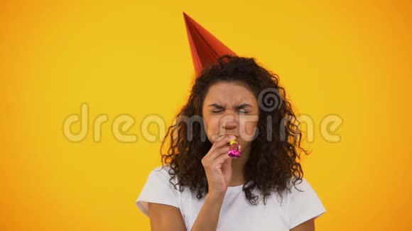 滑稽的混血女人吹着派对的号角努力庆祝生日视频的预览图