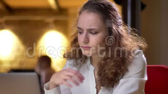 一张年轻卷发女子的特写照片她在办公室里嗓子疼咳嗽视频的预览图
