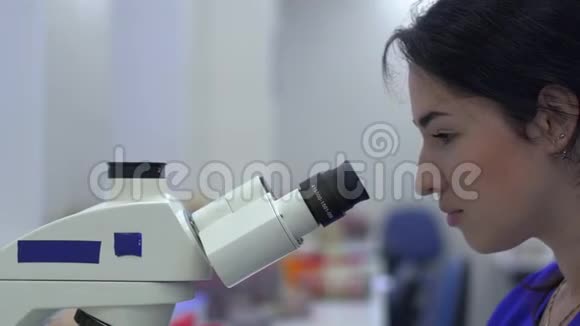 实验室技术人员在显微镜里看视频的预览图