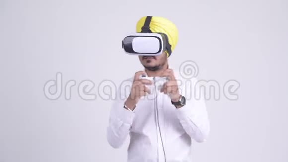 快乐的印度锡克族商人玩虚拟现实耳机游戏视频的预览图