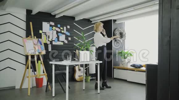 女商人在现代办公室用电话解释视频的预览图