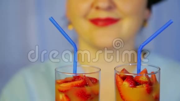 一个女厨师手里拿着鲜奇异果和草莓的鸡尾酒视频的预览图