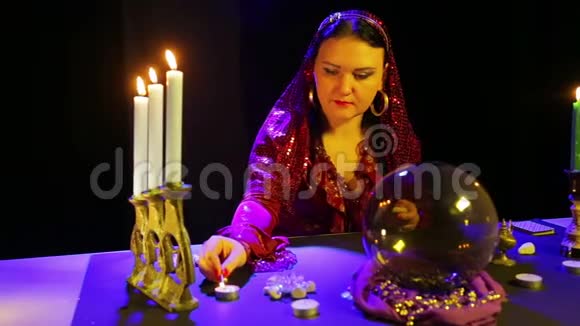 穿着红裙子戴围巾的吉普赛人点燃桌上的蜡烛视频的预览图