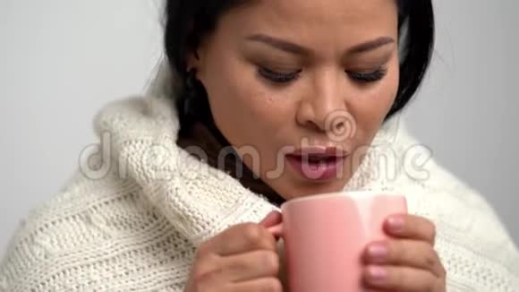 在她的饮料上吹着的亚洲女人视频的预览图