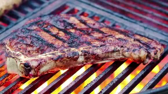 烤牛排烙铁篦子上有烤痕滚烫的木炭喷出浓烟和火焰视频的预览图