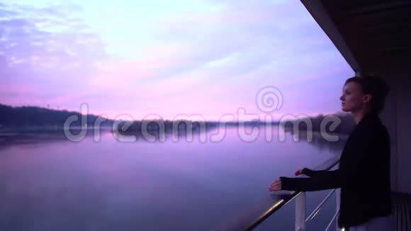 恋爱中的情侣站在酒店的阳台上欣赏着冬天的河景拥抱爱人的男人视频的预览图