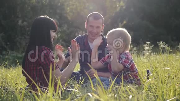 家庭幸福绿茵场上的家庭玩家庭游戏在公园里乐趣是家庭的幸福和休闲视频的预览图