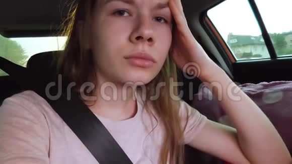 女孩坐在汽车后座上系着安全带视频的预览图