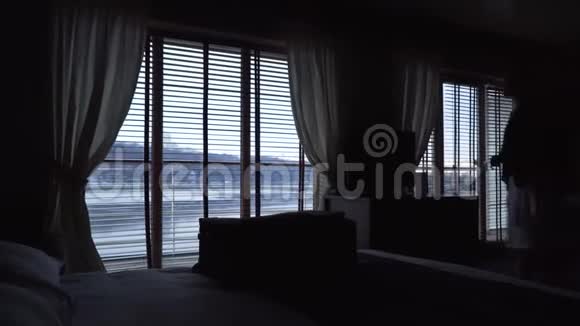 酒店房间里的百叶窗男人和女人站在窗边视频的预览图