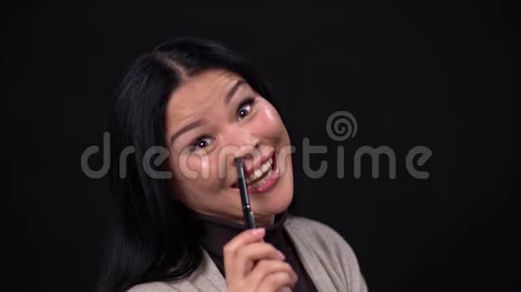 微笑的亚洲人用笔触摸她的脸视频的预览图