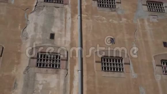 一座监狱建筑的石墙有带金属栏杆的牢房窗户视频的预览图