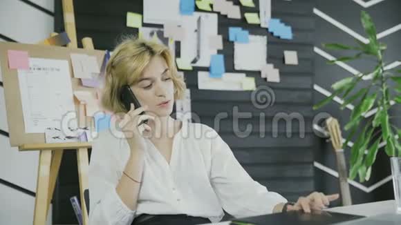 年轻的女商人在她的智能手机上聊天视频的预览图