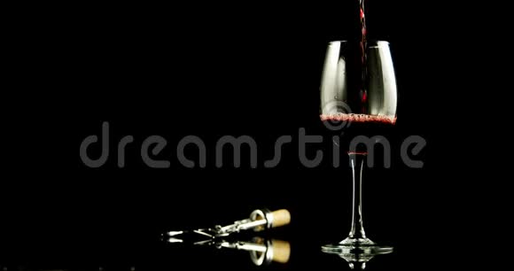 红酒倒在黑背景下的酒杯里视频的预览图