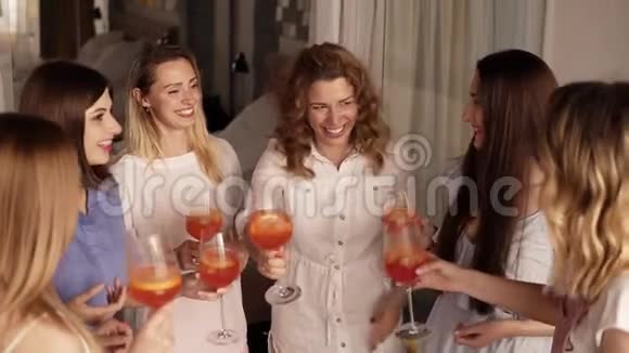 六个女孩站在一个紧密的圆圈里交流庆祝喝杯饮料干杯印度支视频的预览图