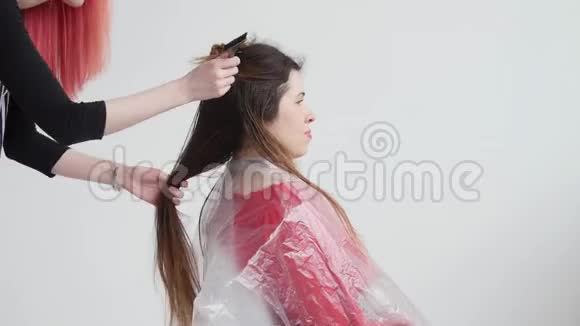 头发红的年轻女子给理发师的女人理发视频的预览图