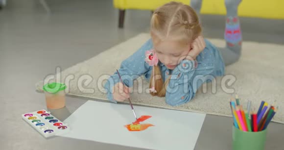 艺术家可爱的女孩在地板上画画视频的预览图