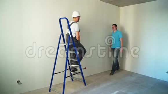 施工现场两名工人在墙上贴墙纸视频的预览图
