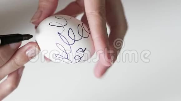 复活节时一个拿着记号笔的不可辨认的女人在鸡蛋上画黑色图案复活节假期的概念视频的预览图