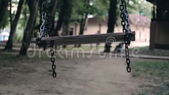 空荡的秋千在黑暗公园的中央随风飘荡绑架儿童的概念视频的预览图