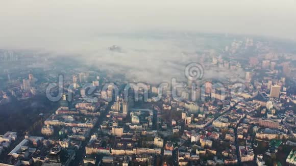 从高空俯瞰到城市上空的浓雾城市里的烟雾或雾环境污染问题视频的预览图
