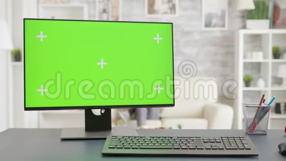 在明亮的客厅里有独立的模拟绿色屏幕显示的PC屏幕视频的预览图